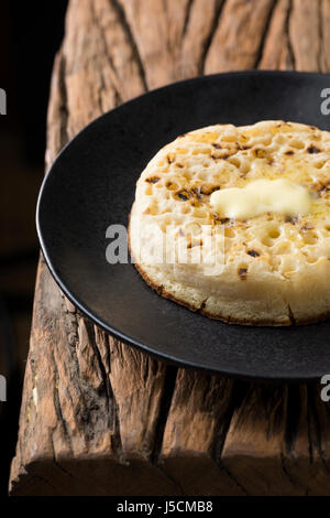 Toasted crumpets on a rustic wooden table. Stock Photo