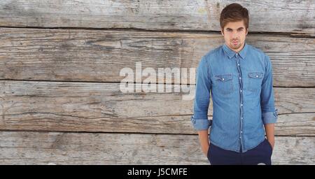 Digital composite of Male hipster with hands in pockets against wooden wall Stock Photo