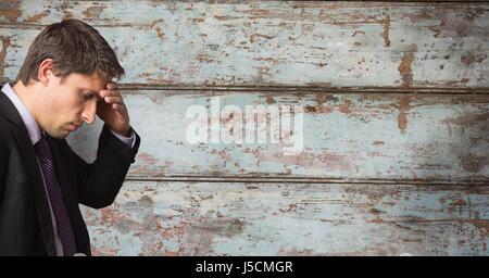 Digital composite of Businessman suffering from headache over wooden wall Stock Photo