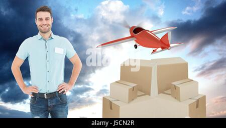 Digital composite of Smiling delivery man with boxes and plane flying in background Stock Photo