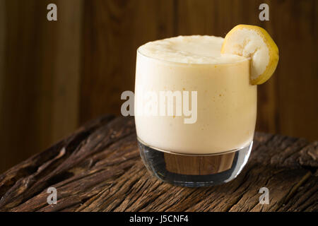 A Glass of fresh mango or bannana fruit smoothie, on a rustic wooden background. Stock Photo