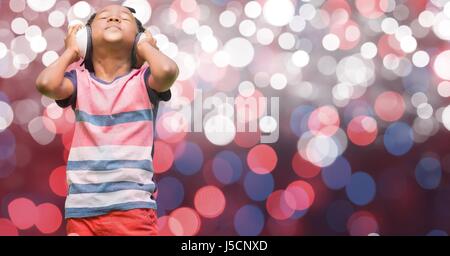 Digital composite of Boy listening music through headphones over glowing bokeh Stock Photo