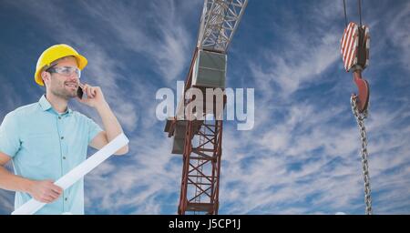 Digital composite of Architect using mobile phone while holding blue print by crane against sky Stock Photo