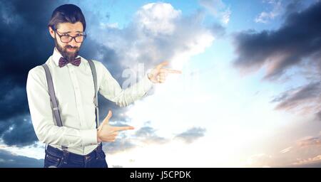 Digital composite of Male hipster pointing against cloudy sky Stock Photo