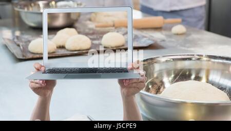 Digital composite of Hands holding laptop while photographing dough Stock Photo