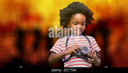 Digital composite of Boy using camera over bokeh Stock Photo