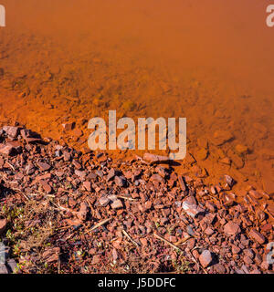 Soil and water in the reservoir of industrial mine water discharge Stock Photo