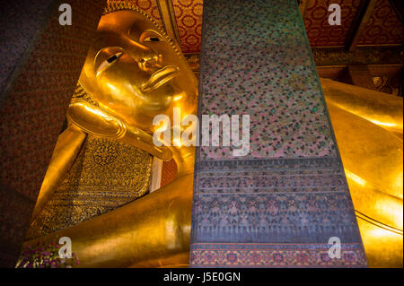 Close-up of the giant golden statue at the Temple of the Reclining Buddha in Bangkok, Thailand Stock Photo