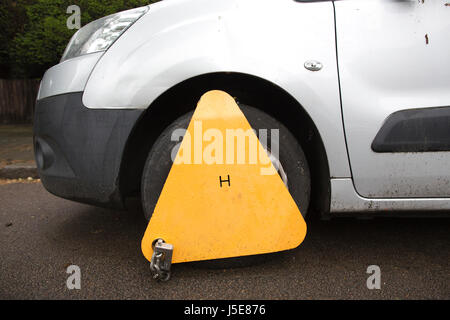 Impounded vehicle parked on street with vehicle immobiliser fitted (wheel clamp) by local authority, Merton, Southwest London, UK Stock Photo