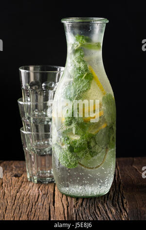 A bottle of soda and drinking glasses. Sitting on a rustic wooden bar. Stock Photo