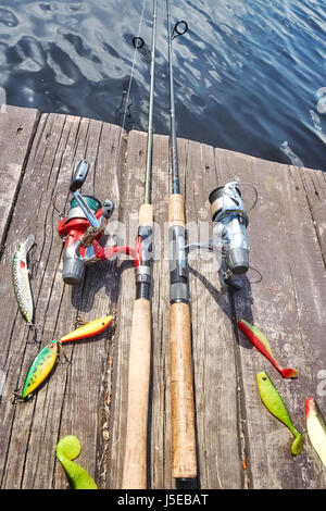 Fishing equipment with artificial spinning lures on a wooden pier. Stock Photo