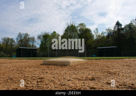 A dusty second base is the center of this baseball field photo. Stock Photo