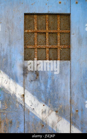 Weathered blue painted metal surface covered with dense vertical rust ...