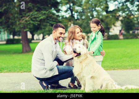 happy family with labrador retriever dog in park Stock Photo