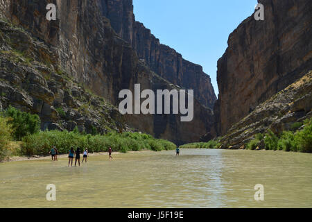 Tourists wade in the low waters of the Rio Grande at the Santa Elena Canyon in Big Bend National Park, Texas. Stock Photo