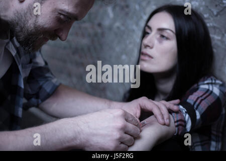 Apathetic addicts making drug injection in the dark place Stock Photo
