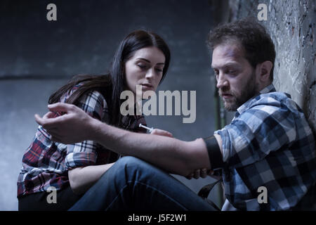 Indifferent drug addicted couple making heroin injection indoors Stock Photo