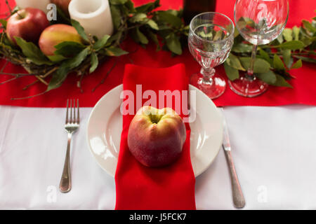 Decorated table ready for dinner. Beautifully decorated table set with flowers, candles, plates and serviettes for wedding or another event in the res Stock Photo