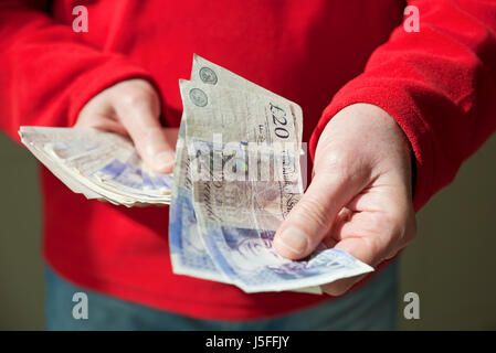 Close up of man person holding British cash money banknotes £20 twenty pound pounds notes England UK United Kingdom GB Great Britain Stock Photo