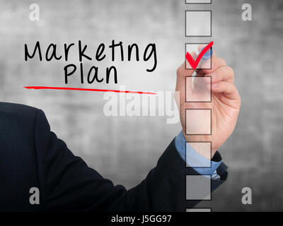 Businessman hand writing Marketing Plan and check listing task. Isolated on grey background. Stock photo Stock Photo