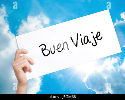 Buen Viaje (Good Trip in Spanish) Sign on white paper. Man Hand Holding Paper with text. Isolated on sky background.   Business concept. Stock Photo Stock Photo