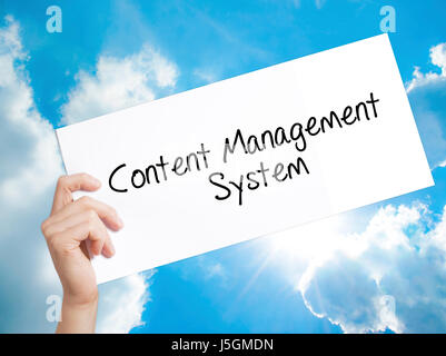 Content Management System  Sign on white paper. Man Hand Holding Paper with text. Isolated on sky background.   Business concept. Stock Photo Stock Photo