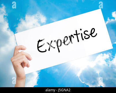 Expertise Sign on white paper. Man Hand Holding Paper with text. Isolated on sky background.  Business concept. Stock Photo Stock Photo