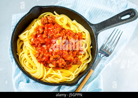 Pasta Bolognese in a cast-iron frying pan. Stock Photo