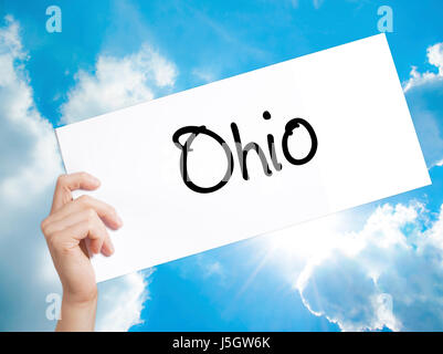 Ohio  Sign on white paper. Man Hand Holding Paper with text. Isolated on sky background.  Business concept. Stock Photo Stock Photo