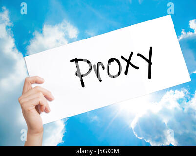 Proxy Sign on white paper. Man Hand Holding Paper with text. Isolated on sky background.  Business concept. Stock Photo Stock Photo