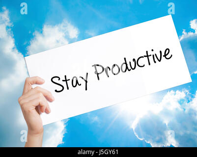 Stay Productive Sign on white paper. Man Hand Holding Paper with text. Isolated on sky background.   Business concept. Stock Photo Stock Photo