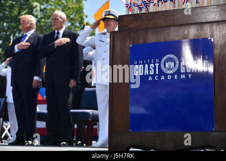 New London, USA. 17th May, 2017. U.S. President Donald Trump, Homeland Security Secretary John Kelly, center, and Coast Guard Commandant Adm. Paul Zukunft salutes during the national anthem at the 136th Coast Guard Academy commencement ceremony May 17, 2017 in New London, Connecticut. Credit: Planetpix/Alamy Live News Stock Photo