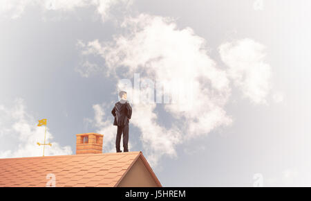 Mister boss on brick roof with arms akimbo. Mixed media Stock Photo