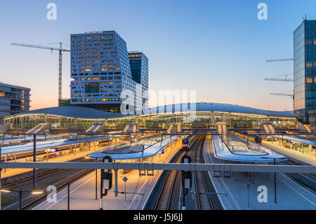 The City Hall and Utrecht Centraal railway station with platforms, railways and trains during sunset. Utrecht, The Netherlands. Stock Photo