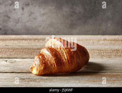 freshly baked croissant on wooden table Stock Photo