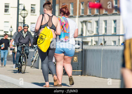 An overweight woman wearing shorts and her friend walking along the promenade on Margate seafront on a sunny day Stock Photo