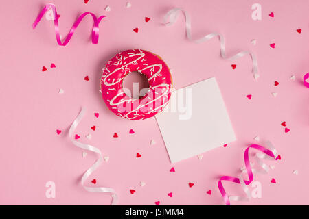 Donuts with icing on pastel pink background with copyspace. Sweet donuts. Stock Photo