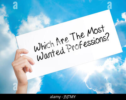 Which Are The Most Wanted Professions? Sign on white paper. Man Hand Holding Paper with text. Isolated on sky background.  Business concept. Stock Pho Stock Photo
