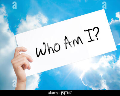 Who Am I? Sign on white paper. Man Hand Holding Paper with text. Isolated on sky background.   Business concept. Stock Photo Stock Photo