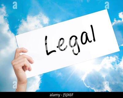 Legal Sign on white paper. Man Hand Holding Paper with text. Isolated on sky background.  Business concept. Stock Photo Stock Photo