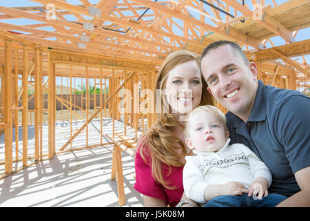 Young Military Family Inside The Framing of Their New Home at Construction Site. Stock Photo