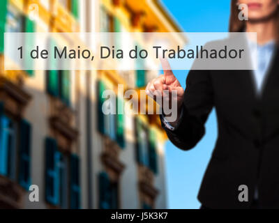 1 de Maio, Dia do Trabalhador (In Portuguese: 1 May, Labor Day) - Isolated female hand touching or pointing to button. Business and future technology  Stock Photo