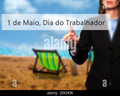 1 de Maio, Dia do Trabalhador (In Portuguese: 1 May, Labor Day) - Isolated female hand touching or pointing to button. Business and future technology  Stock Photo