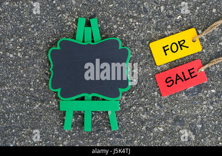 word for sale written on wooden tag with empty space on wooden easel. Stock Photo