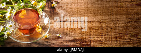 Black tea with mint and chamomiles on wooden background Stock Photo