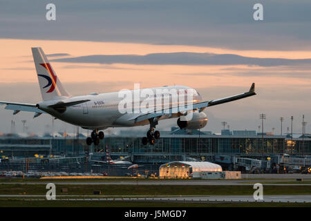 China Eastern Airlines plane airplane landing Vancouver International Airport terminal exterior dusk twilight view Airbus A330 jetliner B-5936 Stock Photo