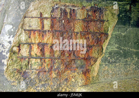 Rusted reinforcing metal showing thru a concrete wall Stock Photo