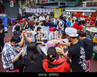 May 18, 2017 - Bangkok, Bangkok, Thailand - People eating at a street food stall in Bangkok's Chinatown. City officials in Bangkok have taken steps to rein in street food vendors. The steps were originally reported as a ''ban'' on street food, but after an uproar in local and international news outlets, city officials said street food vendors wouldn't be banned but would be regulated, undergo health inspections and be restricted to certain hours on major streets. On Yaowarat Road, in the heart of Bangkok's touristy Chinatown, the city has closed some traffic lanes to facilitate the vendors. Bu Stock Photo