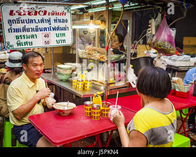 May 18, 2017 - Bangkok, Bangkok, Thailand - People eating at a street food stall in Bangkok's Chinatown. City officials in Bangkok have taken steps to rein in street food vendors. The steps were originally reported as a ''ban'' on street food, but after an uproar in local and international news outlets, city officials said street food vendors wouldn't be banned but would be regulated, undergo health inspections and be restricted to certain hours on major streets. On Yaowarat Road, in the heart of Bangkok's touristy Chinatown, the city has closed some traffic lanes to facilitate the vendors. Bu Stock Photo
