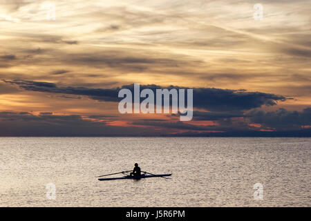 Sport. Solitary rower during his training session in the sunset light. Stock Photo